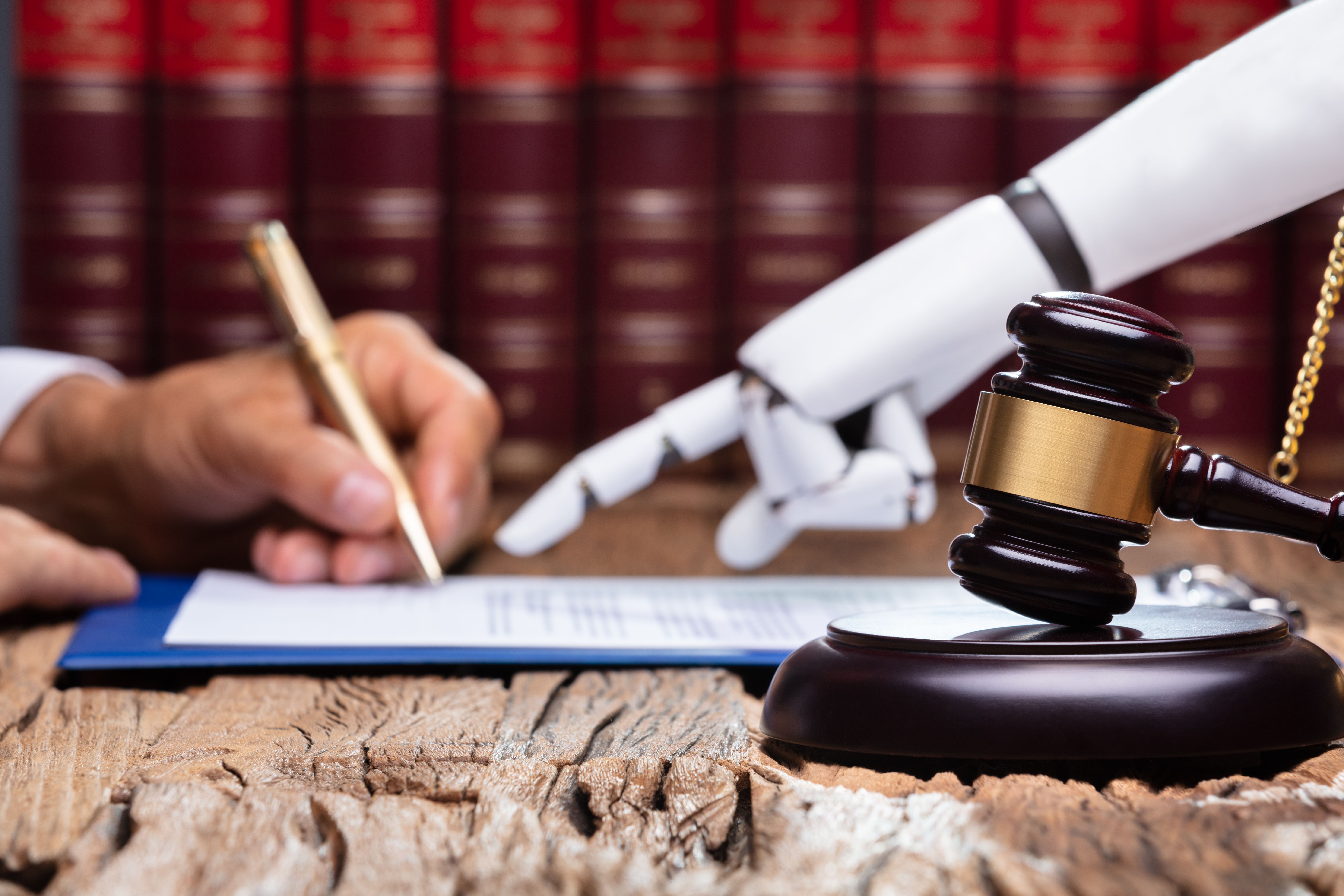 Das Bild zeigt eine Hand die einen Stift hält, sowie eine Roboterhand, die der menschlichen Hand zeigt, wo sie unterschrieben soll.