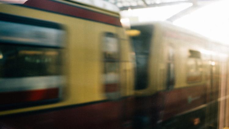 Die Berliner S-Bahn fährt morgens bei Sonnenaufgang in den Hauptbahnhof in Deutschland ein.