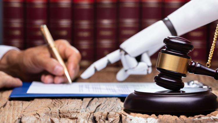 Das Bild zeigt eine Hand die einen Stift hält, sowie eine Roboterhand, die der menschlichen Hand zeigt, wo sie unterschrieben soll.