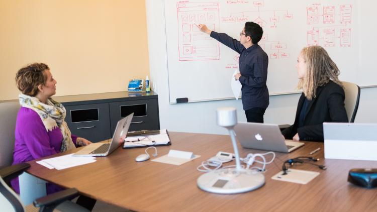 Drei weibliche Personen arbeiten in einem Konferenzraum