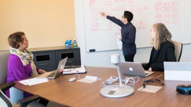 Drei weibliche Personen arbeiten in einem Konferenzraum